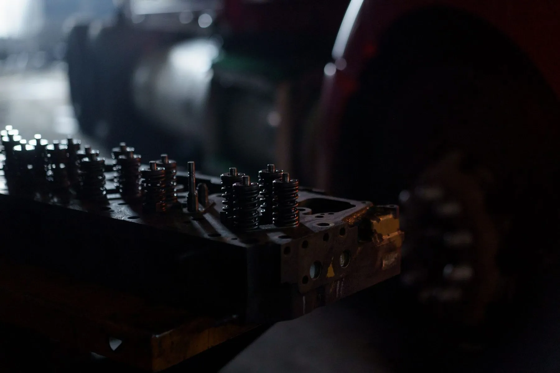 A cylinder head with its valve springs on the bench in a dark workshop